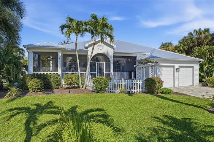 Ranch-style home with a metal roof, a front yard, driveway, and a sunroom
