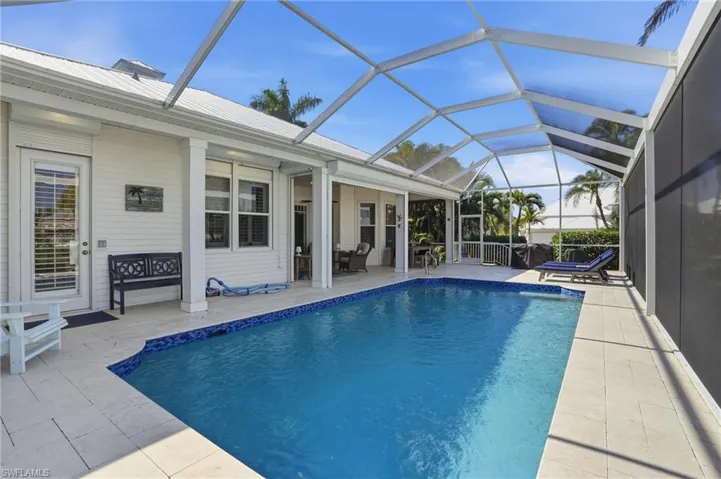 Outdoor pool with a sunroom, a patio area, and a lanai