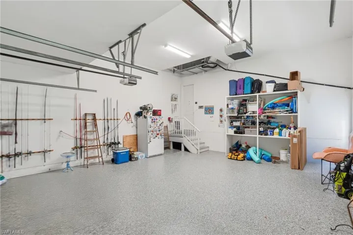 Garage featuring freestanding refrigerator and a garage door opener