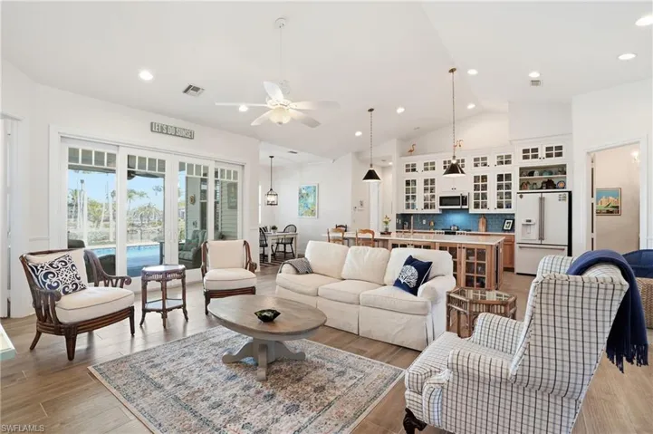 Living area featuring light wood-type flooring, ceiling fan, recessed lighting, and lofted ceiling