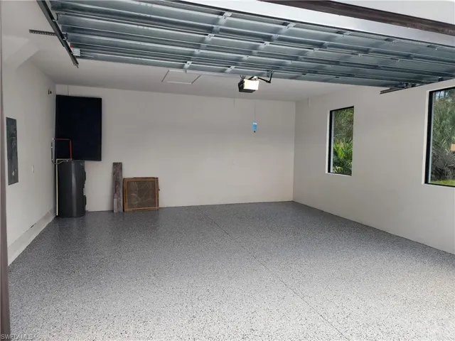 Garage featuring electric panel and electric water heater