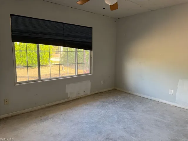 Spare room featuring a ceiling fan and baseboards