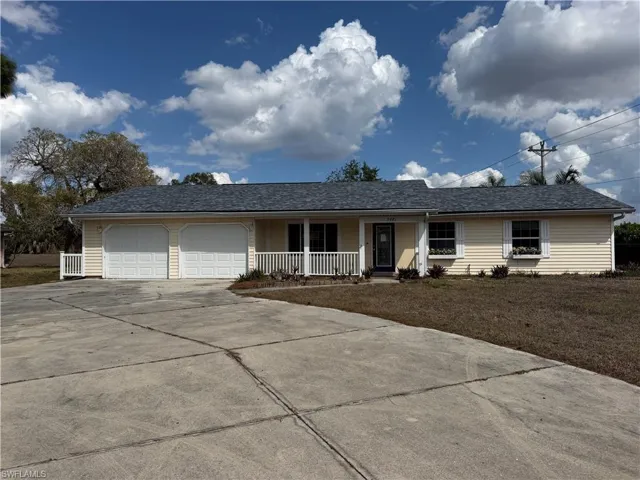 Ranch-style home featuring a garage, concrete driveway, and covered porch