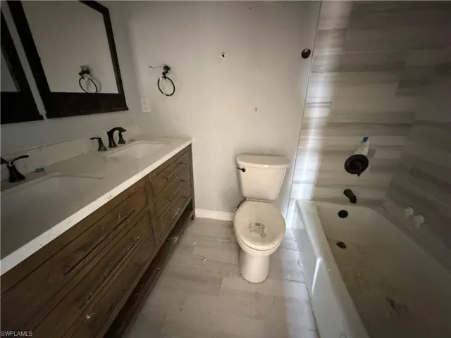Bathroom with double vanity and tub / shower combination