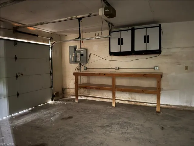 Garage featuring electric panel and a garage door opener