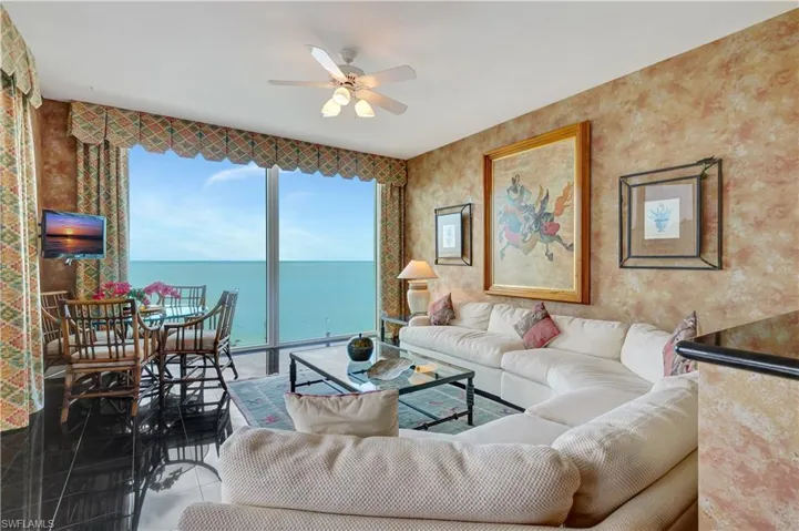 Tiled living room with plenty of natural light and ceiling fan
