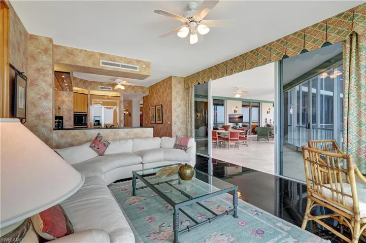 Living room with ceiling fan and tile patterned flooring