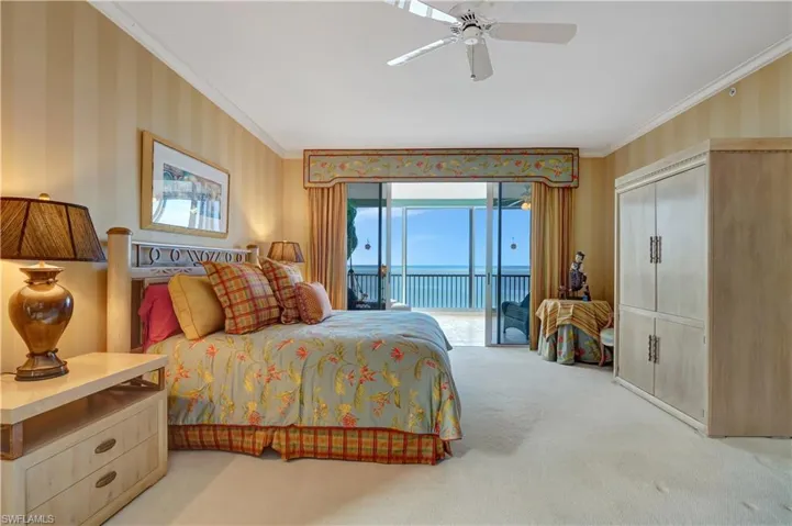 Carpeted bedroom with access to exterior, a water view, ceiling fan, and ornamental molding