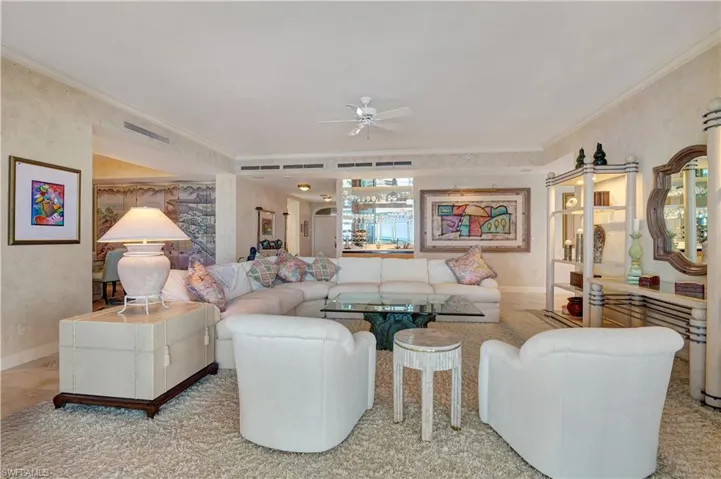 Living room with crown molding and ceiling fan