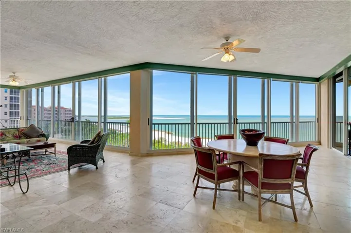 Sunroom / solarium featuring a water view and ceiling fan