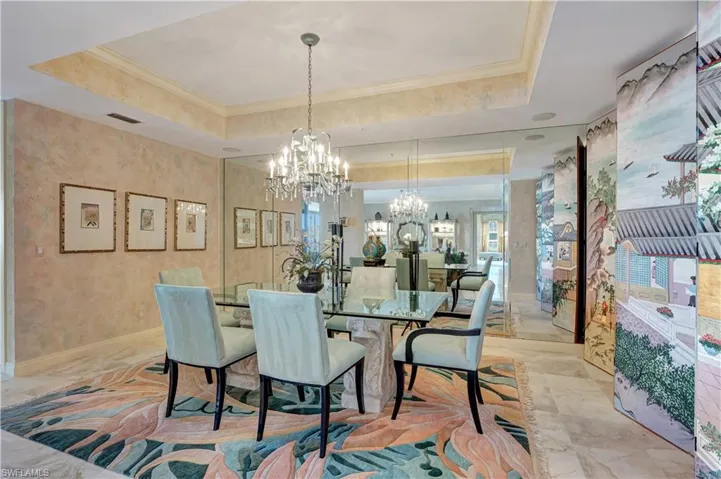 Dining space featuring an inviting chandelier, crown molding, and a tray ceiling