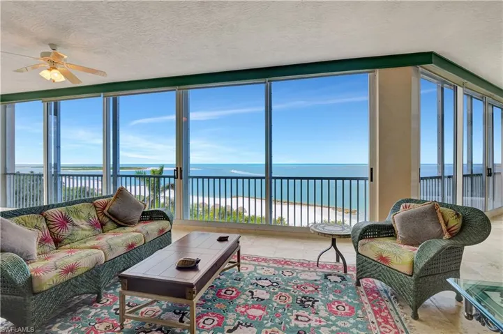 Sunroom featuring ceiling fan and a water view