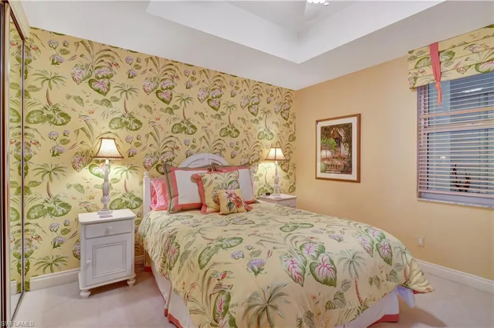 Bedroom with ceiling fan and light colored carpet