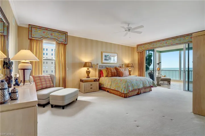 Carpeted bedroom with ceiling fan, multiple windows, access to outside, and a water view