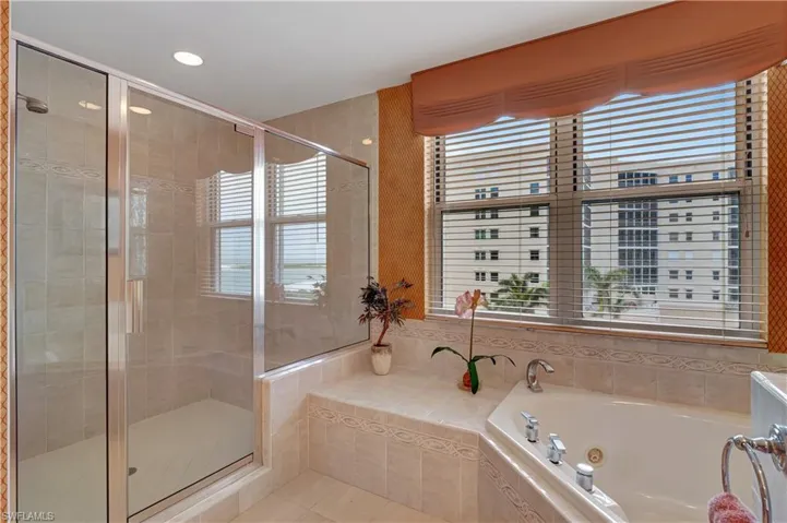 Bathroom featuring plus walk in shower, tile patterned floors, and a wealth of natural light