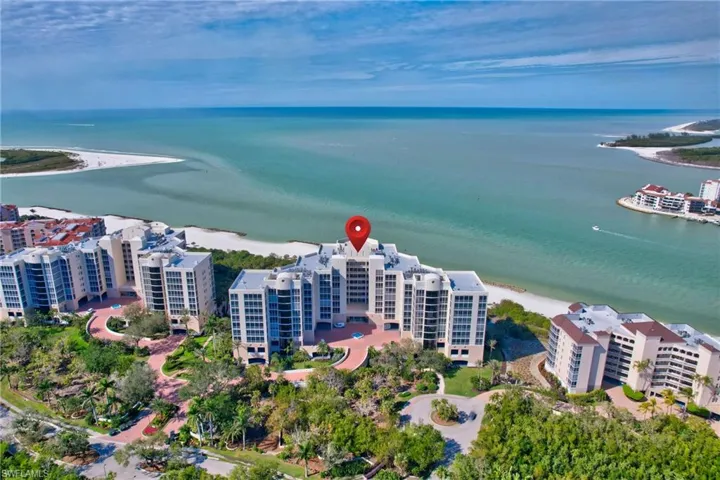Birds eye view of property featuring a water view and a beach view