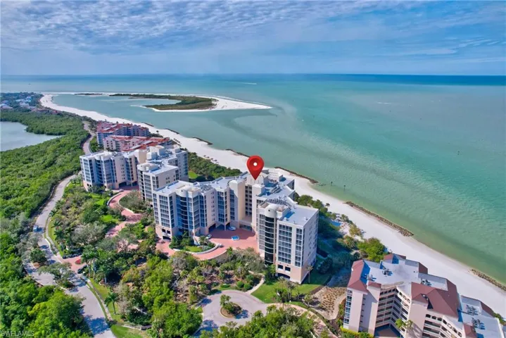 Birds eye view of property featuring a water view and a beach view
