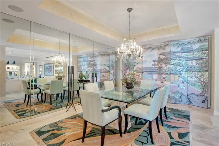 Dining space with a notable chandelier, a tray ceiling, and ornamental molding