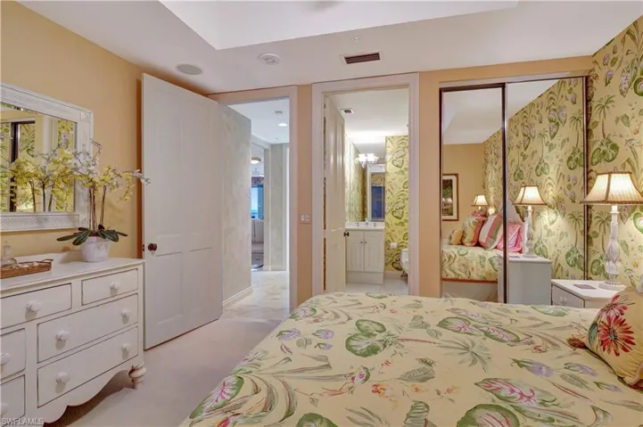 Bedroom featuring a closet, light carpet, and ensuite bath
