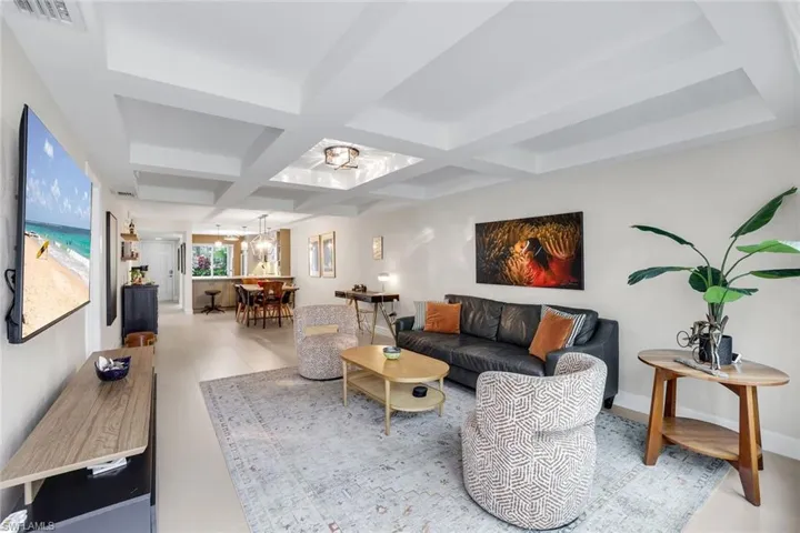 Living area with coffered ceiling and suspended lighting