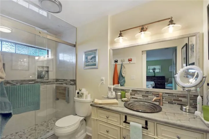 Full bath featuring a stall shower, tasteful backsplash, ensuite bathroom, and vanity