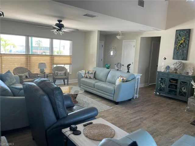 Living room with a ceiling fan and wood-like floors
