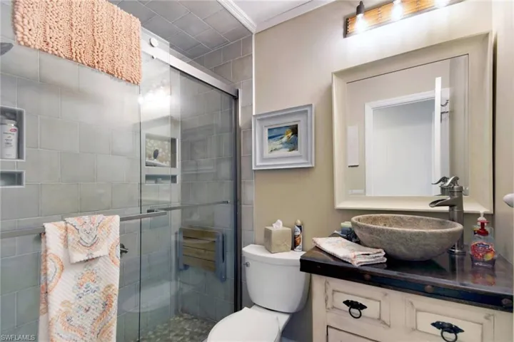 Bathroom featuring vanity, a stall shower, and crown molding