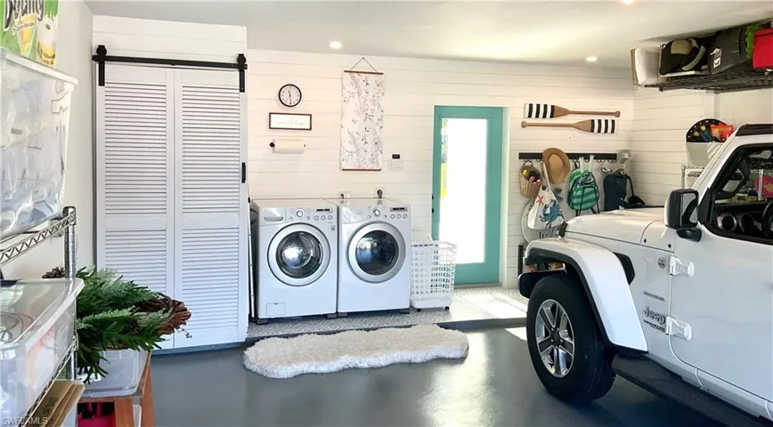Laundry area featuring washer and clothes dryer, concrete floors, recessed lighting, and wooden walls