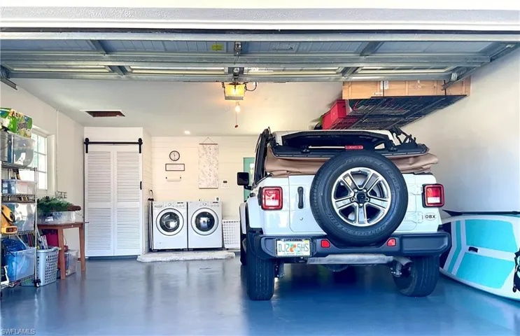 Garage featuring independent washer and dryer and a garage door opener