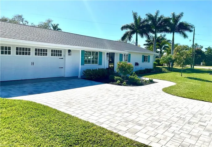 Single story home featuring a front yard, roof with shingles, and stucco siding