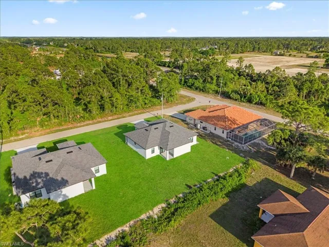 Aerial perspective showcasing multiple properties amidst a verdant landscape
