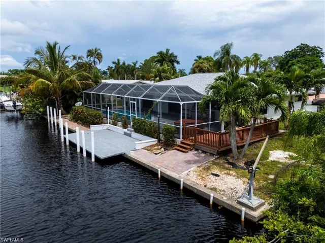 Dock area with glass enclosure, a sunroom, a swimming pool, and a deck with water view