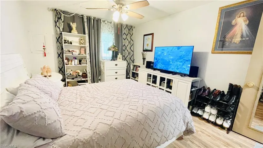 Bedroom with light hardwood / wood-style floors and ceiling fan