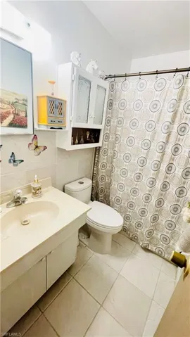 Bathroom with tile flooring, toilet, and large vanity