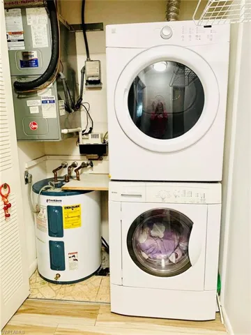 Laundry area featuring stacked washer and clothes dryer and water heater