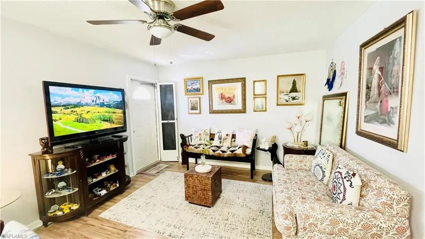 Living room with hardwood / wood-style floors and ceiling fan