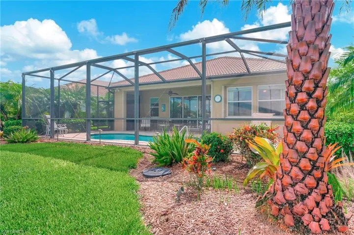 Rear view of house with a yard, a patio, and glass enclosure