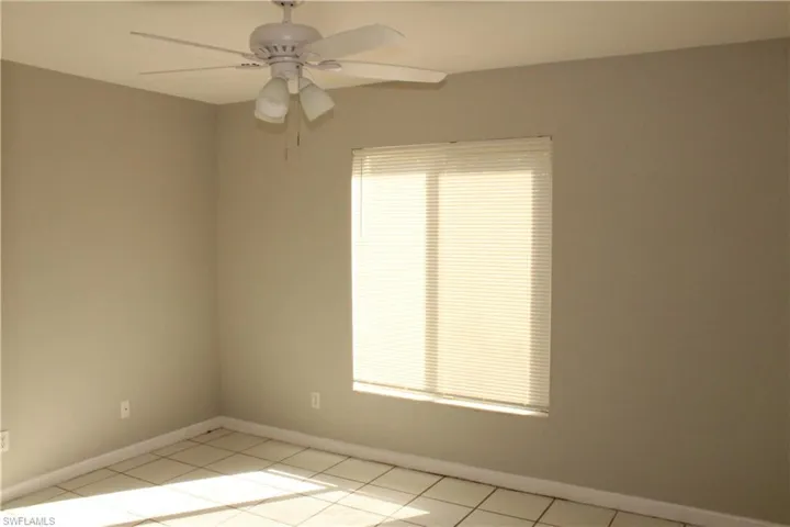 Unfurnished room featuring a ceiling fan and light tile patterned floors