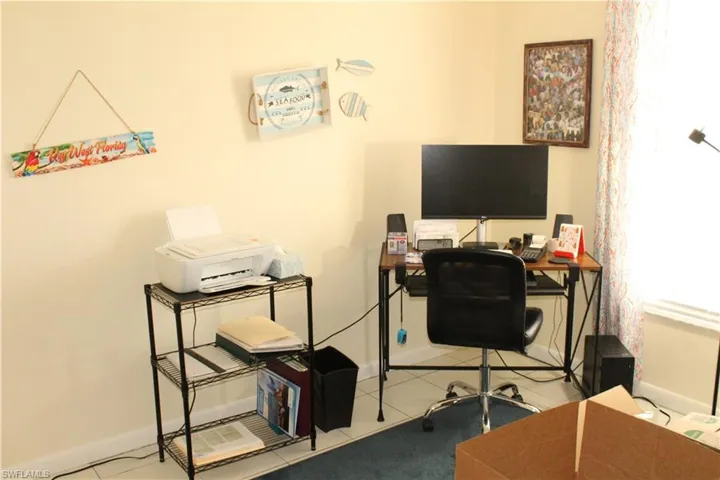 Home office with light tile patterned floors and baseboards