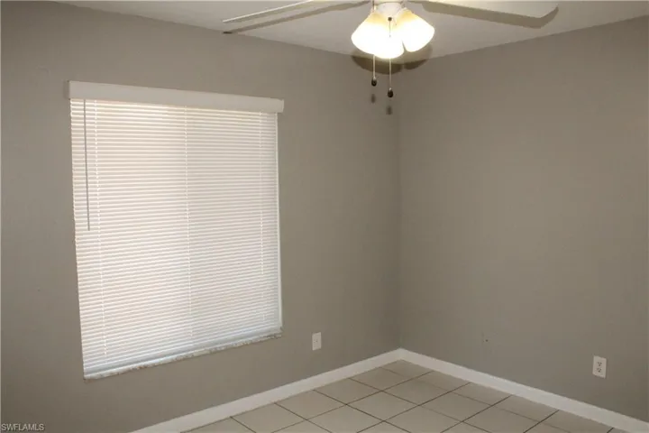 Spare room with ceiling fan and light tile patterned floors