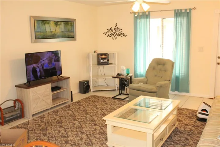 Tiled living room with a ceiling fan