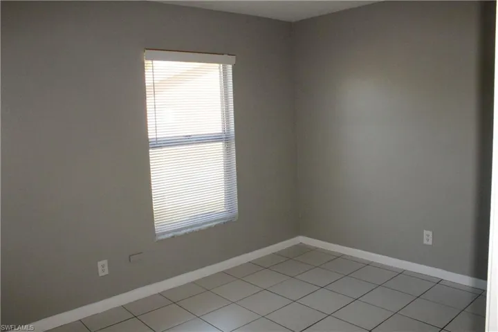 Empty room with baseboards and light tile patterned floors