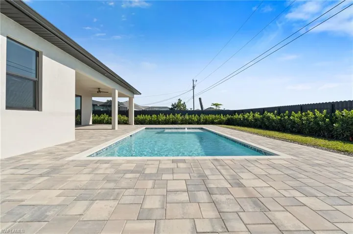 View of swimming pool with ceiling fan and a patio