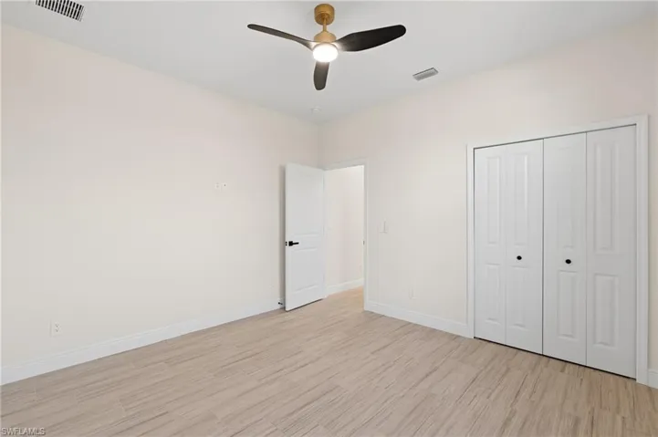 Unfurnished bedroom featuring light Italian tile flooring, a closet, and ceiling fan
