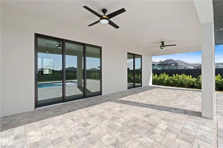 View of patio featuring ceiling fan and a fenced in pool