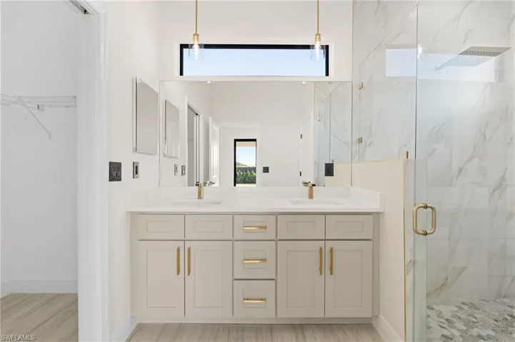 Bathroom featuring Italian tile flooring, vanity, and a shower with glass door