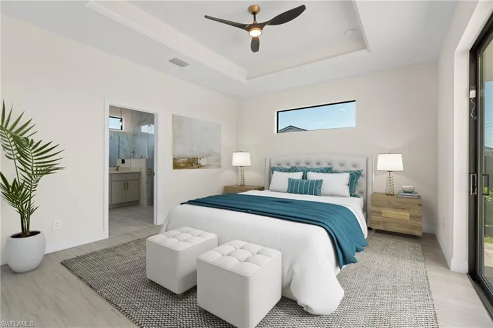 Primary Bedroom featuring ensuite bathroom, access to exterior, ceiling fan, a raised ceiling, and virtually staged