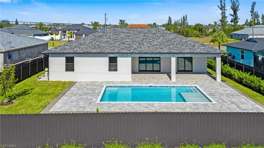 Back of property featuring a fenced in pool and a patio area