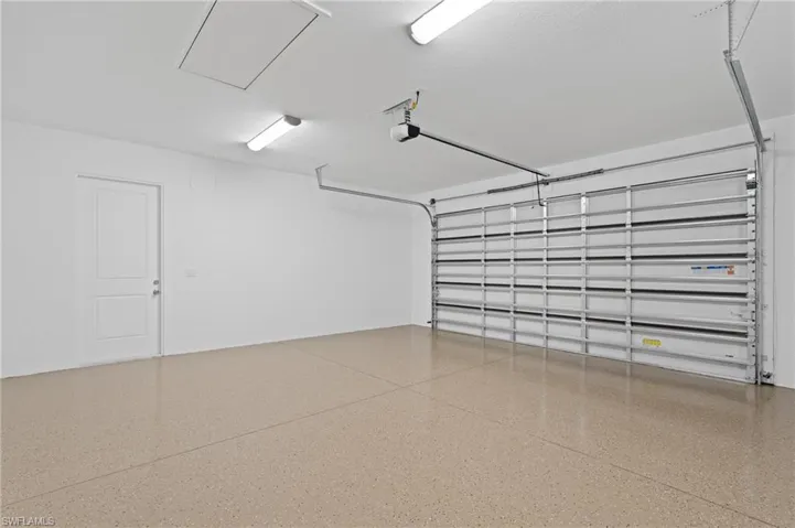Garage featuring a hurricane impact garage door and epoxied floors