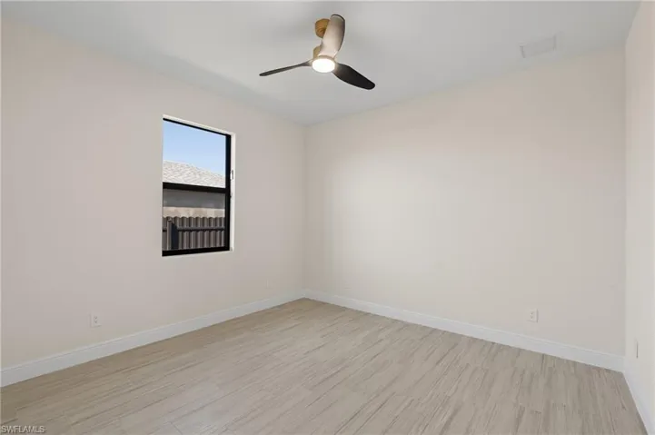 Empty room featuring ceiling fan and light Italian tile flooring